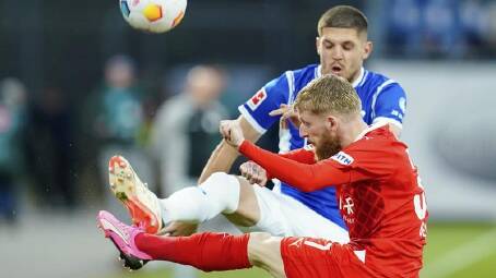 Heidenheim's Jan-Niklas Beste, in red, and Darmstadt's Emir Karic battle in their relegation clash. (AP PHOTO)