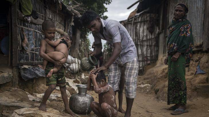 A refugee bathes his child at the Kutupalong  Camp in Teknaaf, Bangladesh. Photo: New York Times